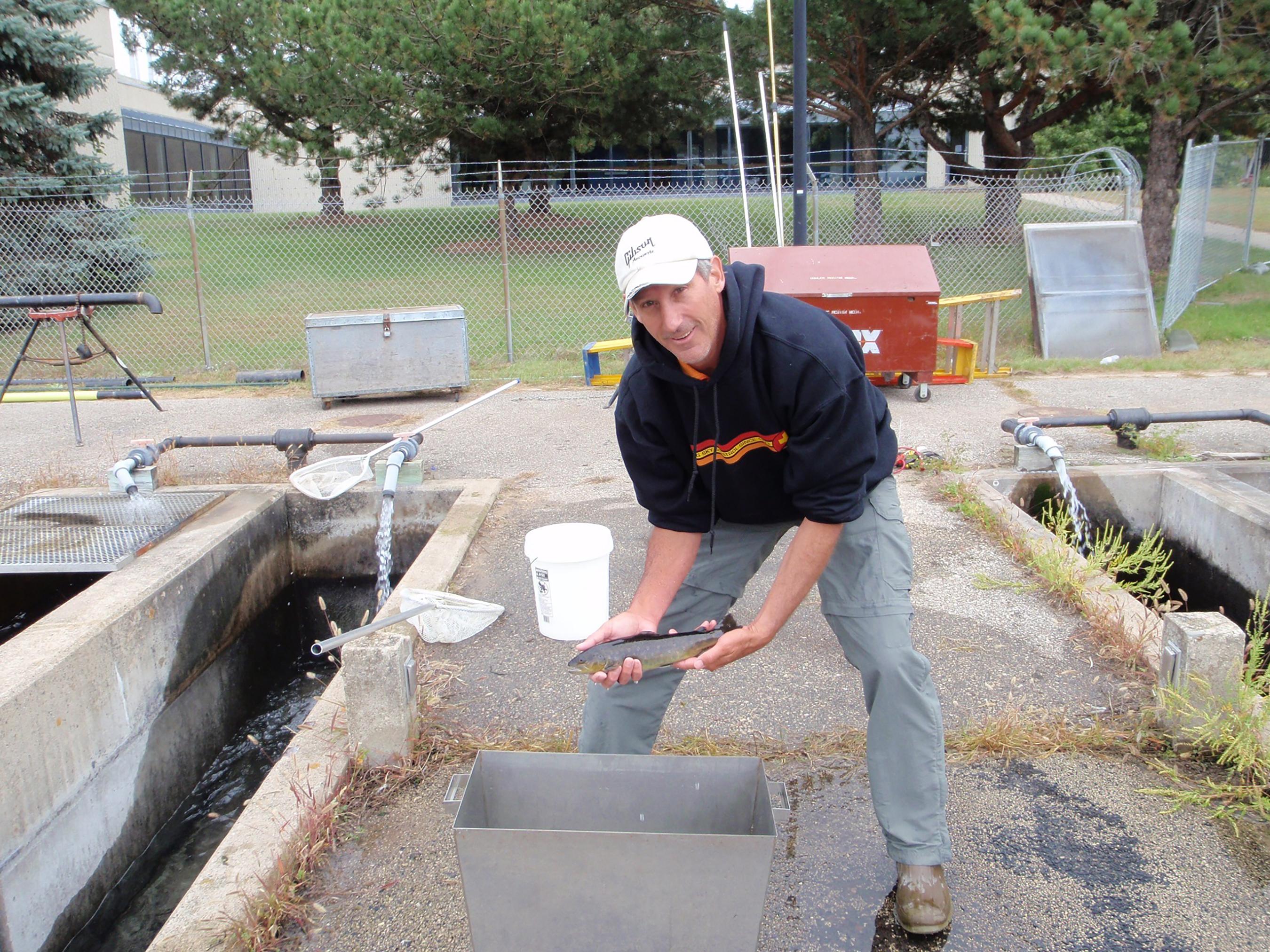 Jim Bowker holding a juvenile fish.